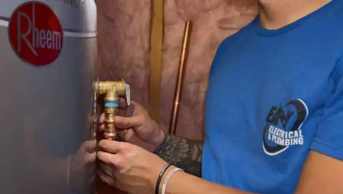 Plumber Installing Brass Valve Rheem Water Heater